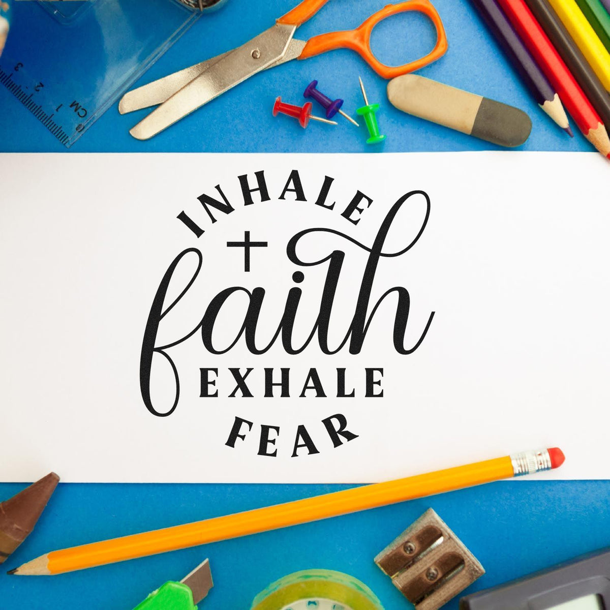 Faith quote stamp and seal on white card, surrounded by colorful school supplies on a blue background.