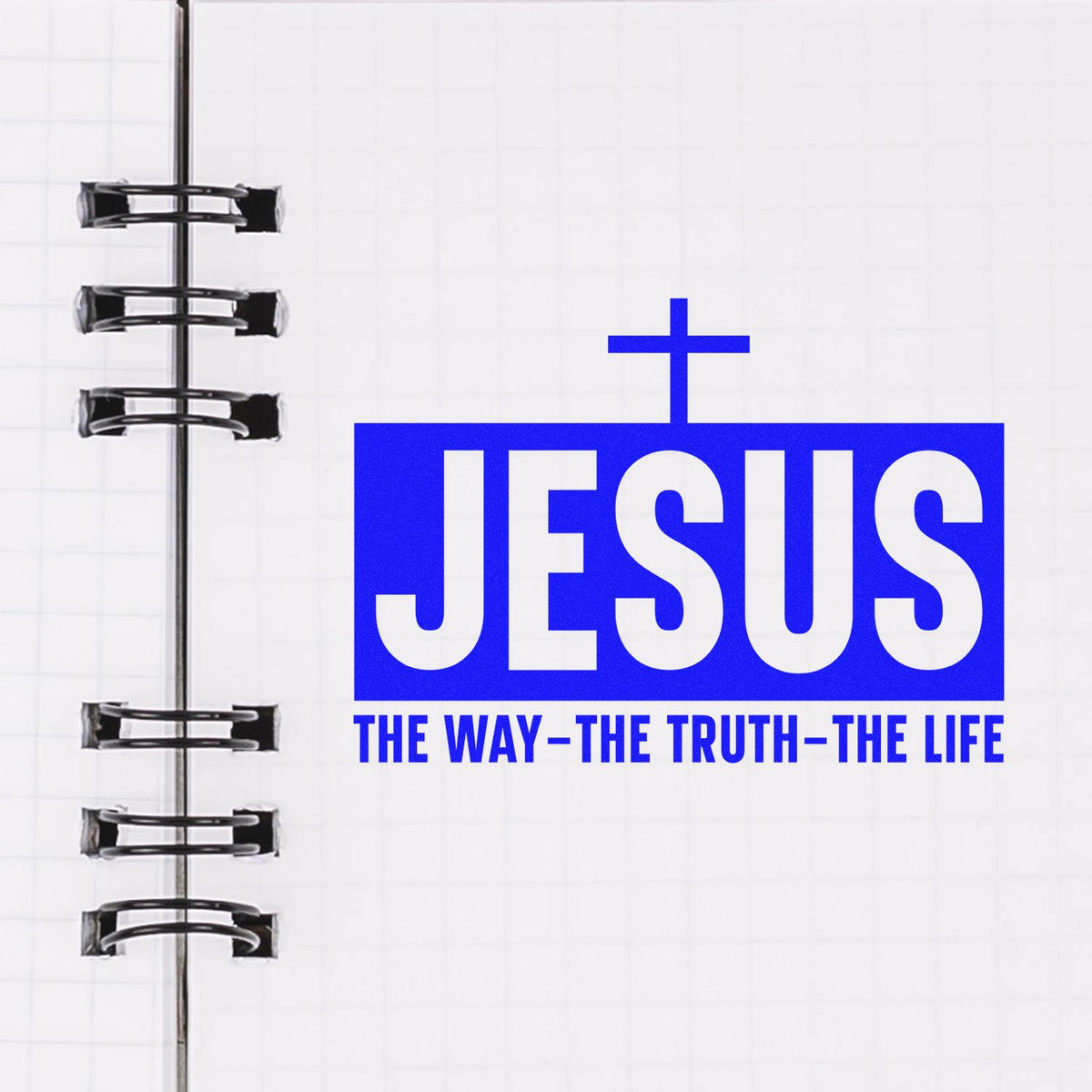 Blue Jesus stamp and seal design with cross and slogan, beside black spiral notebook rings.