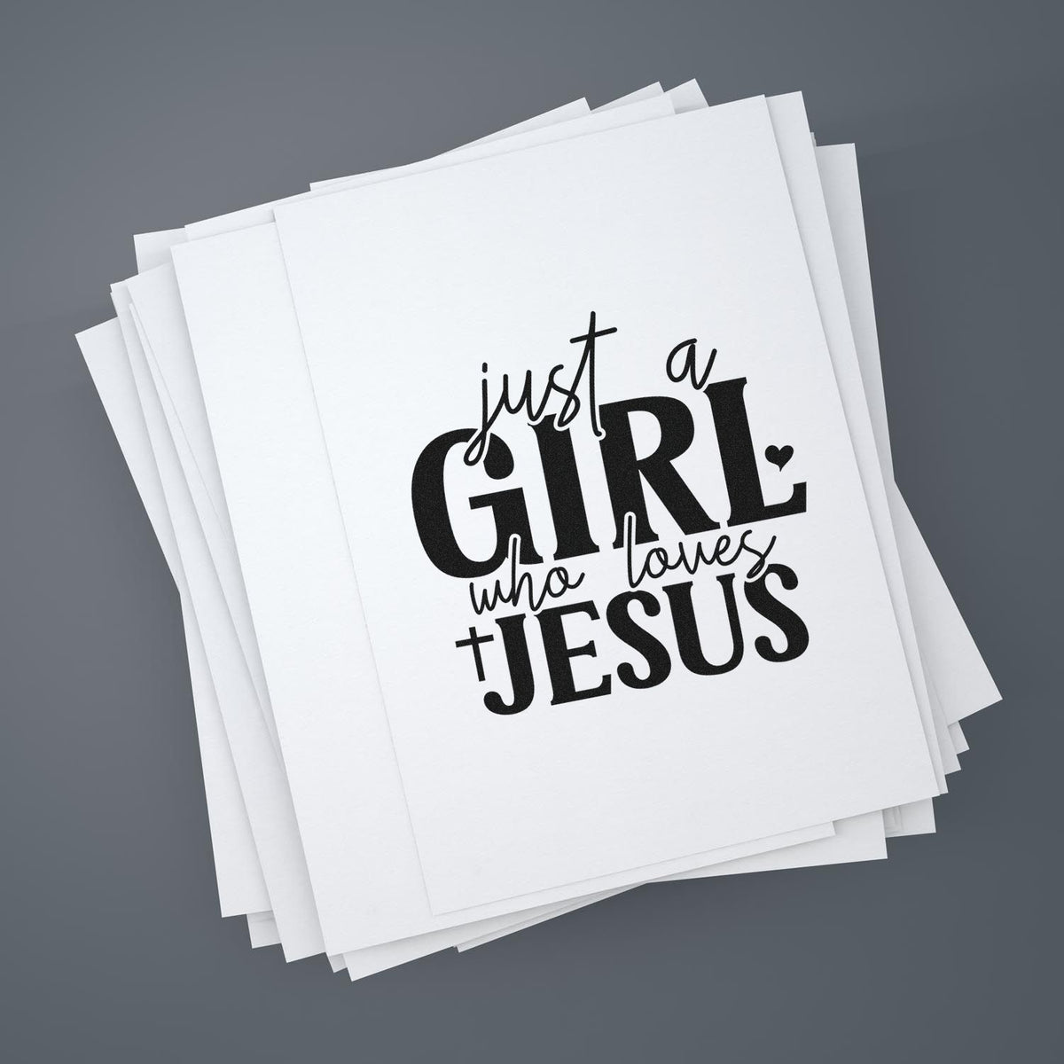 Stacked white stamp and seal cards with black just a GIRL who loves JESUS design on a gray background.