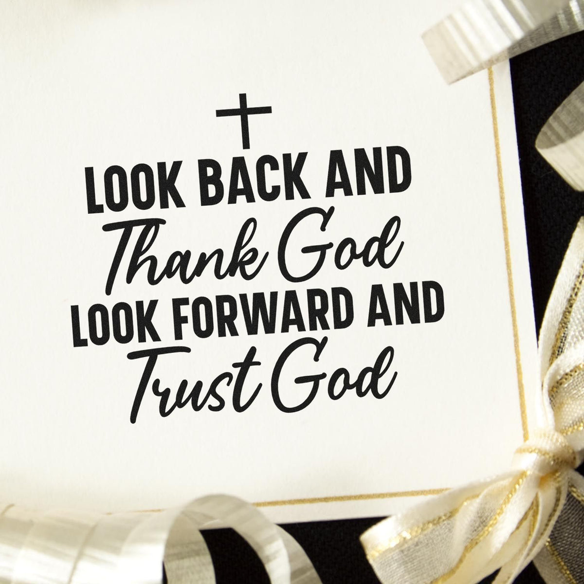 Black faith quote stamp with cross on white card, accented by cream and gold ribbon seals.