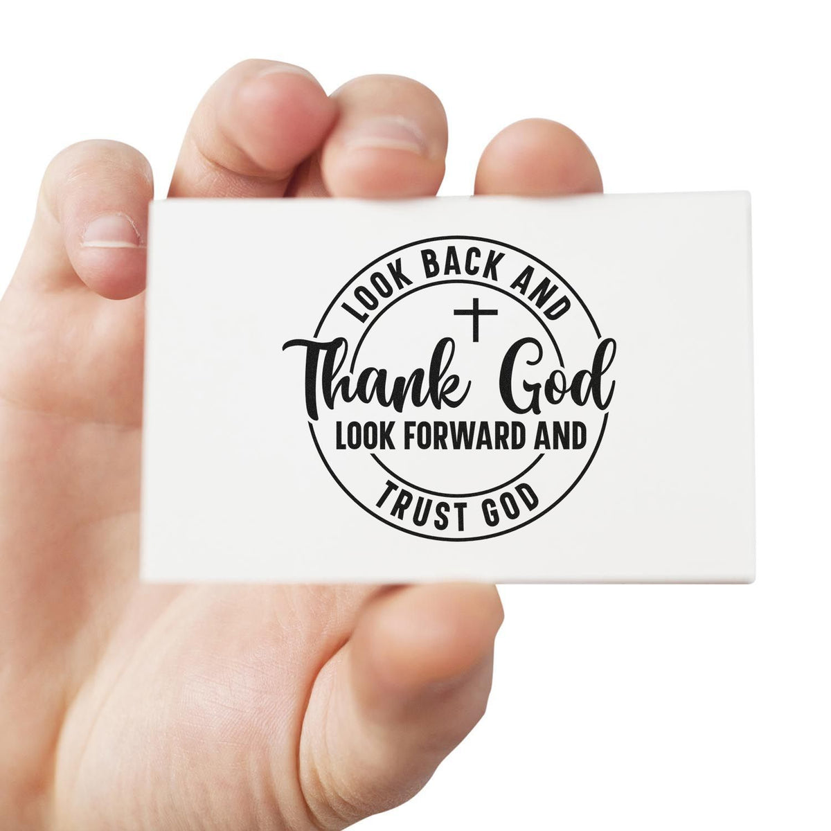 Hand holding white stamp seal with black Christian cross and circular text: Thank God, Trust God.