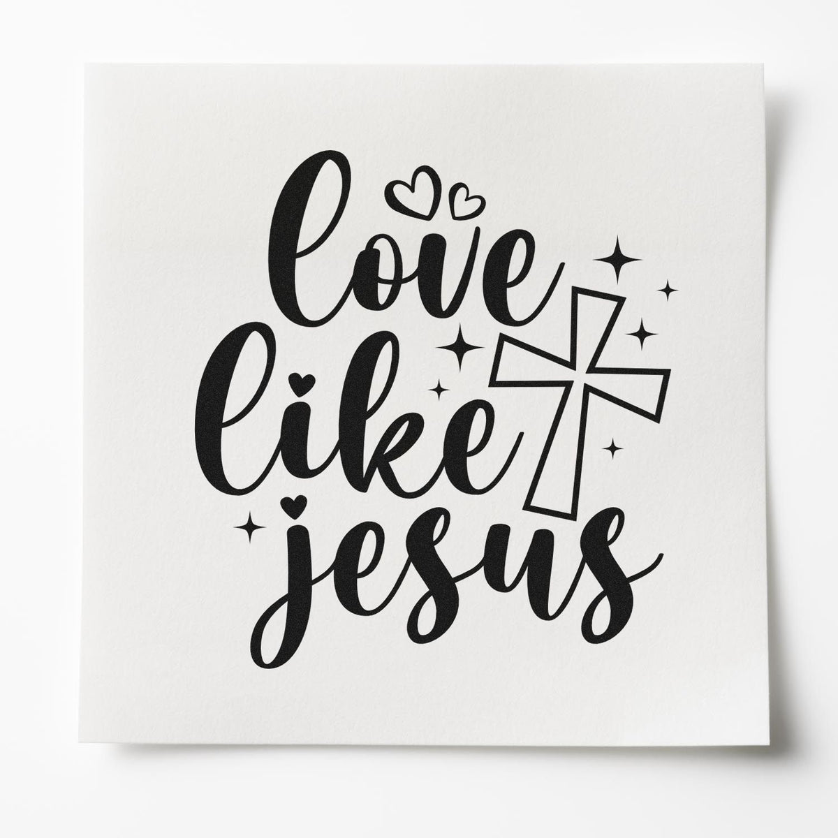 Black love like Jesus stamp seal design with hearts, sparkles, and cross on white cardstock