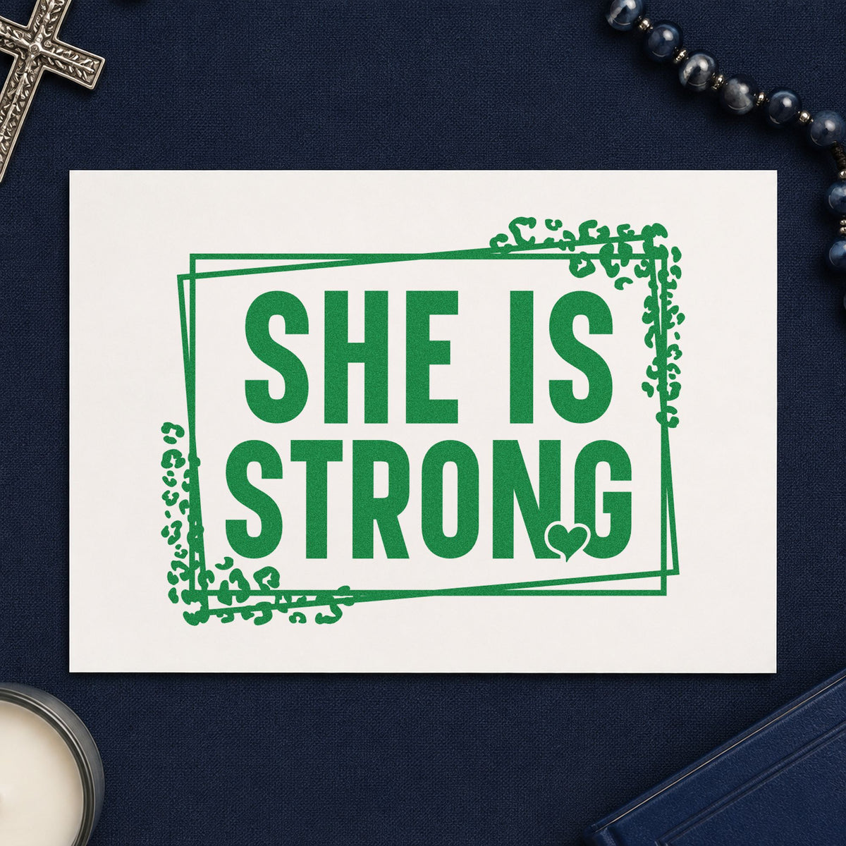She Is Strong craft stamp imprint in green ink on a handmade project, one idea being women's retreat tees.
