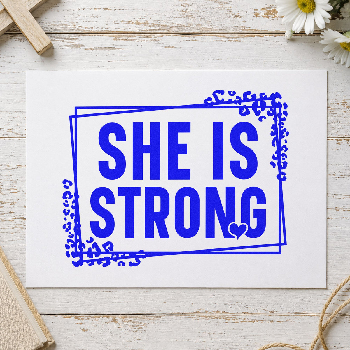 She Is Strong craft stamp imprinted in blue ink on paper, a design suited to graduation gifts.