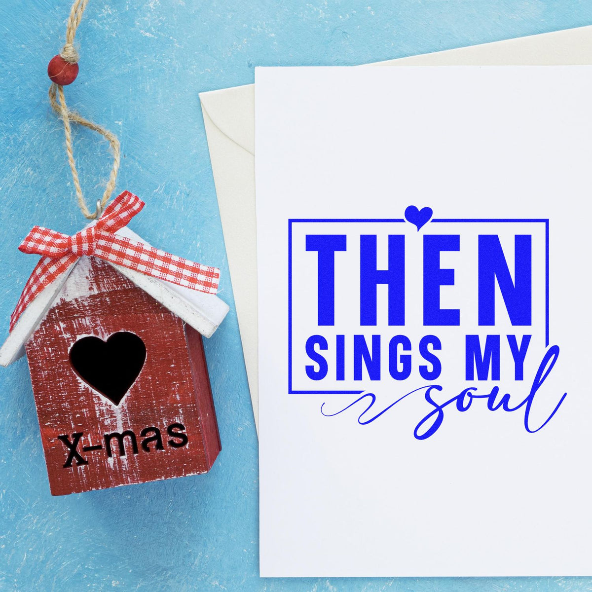 Rustic red birdhouse stamp and seal with heart cutout, next to a white card stamped in blue: Then Sings My Soul.