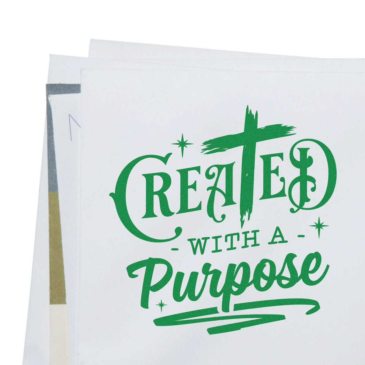 Green custom stamp and seal on white paper reading Created with a Purpose, with decorative stars and layered sheets.