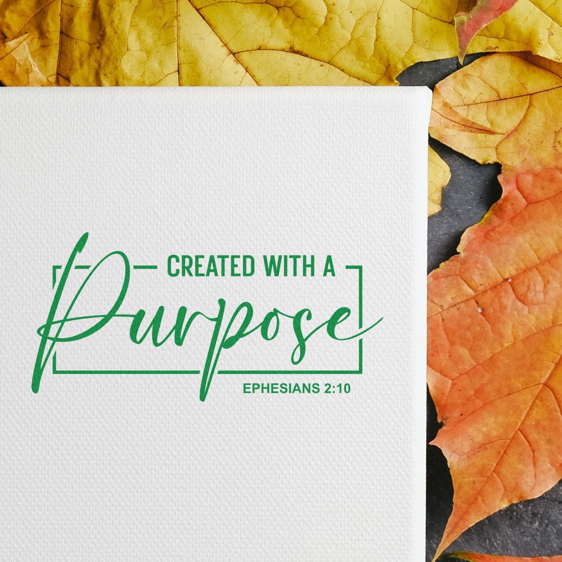 Green Created with a Purpose stamp and seal on white textured paper, with Ephesians 2:10, over autumn leaves.