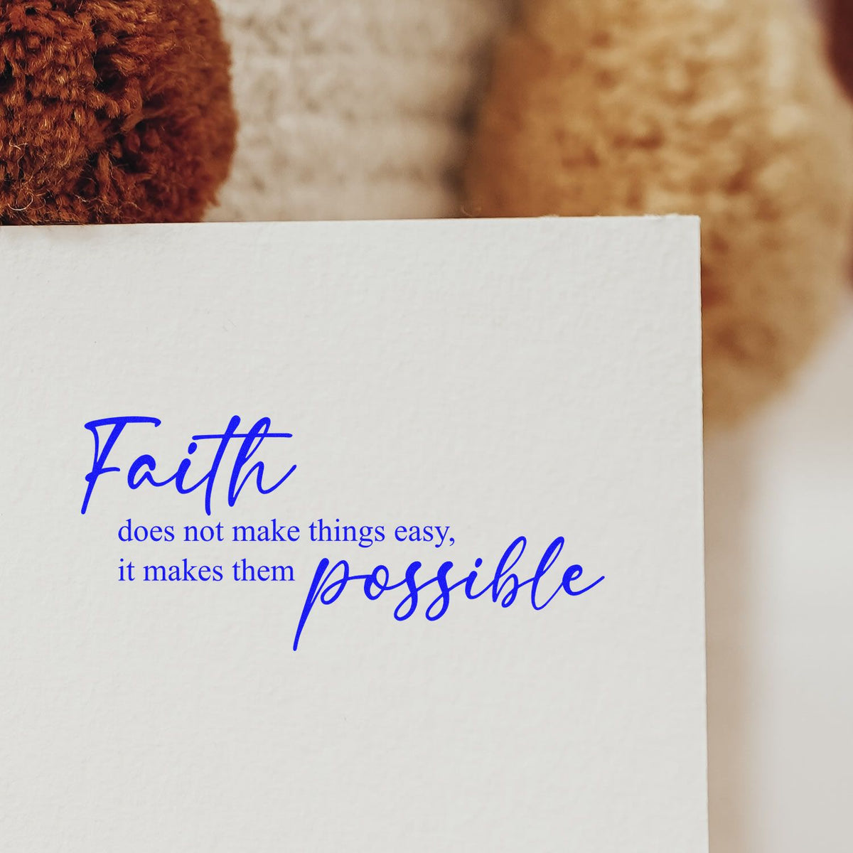 Blue faith quote stamp/seal on white paper: Faith does not make things easy, it makes them possible.