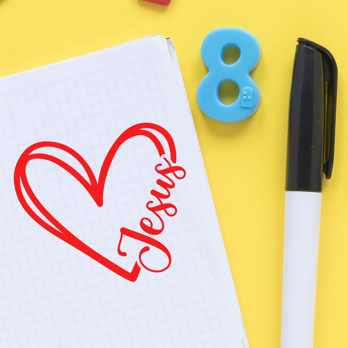 Red heart seal on graph paper, blue number 8 stamp, and black marker on bright yellow background.