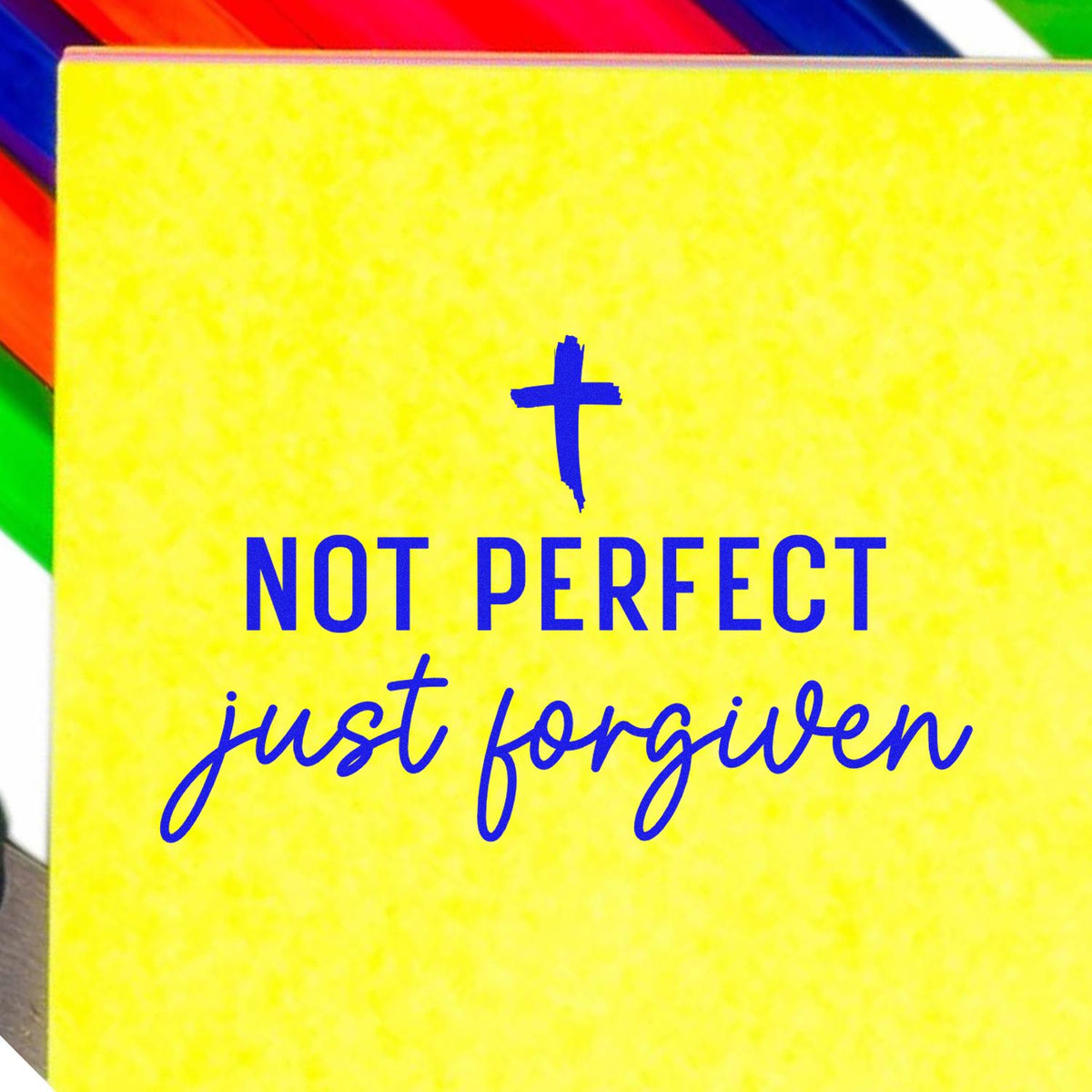 Yellow stamp and seal card with blue cross and Not perfect just forgiven text, framed by rainbow stripes.