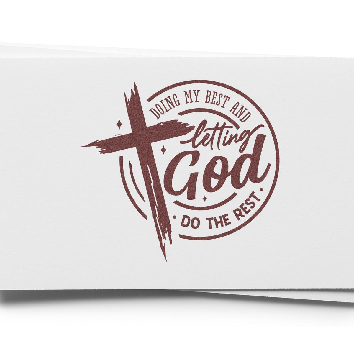 Maroon rubber stamp seal with cross and text, Doing my best and letting God do the rest, on white paper.