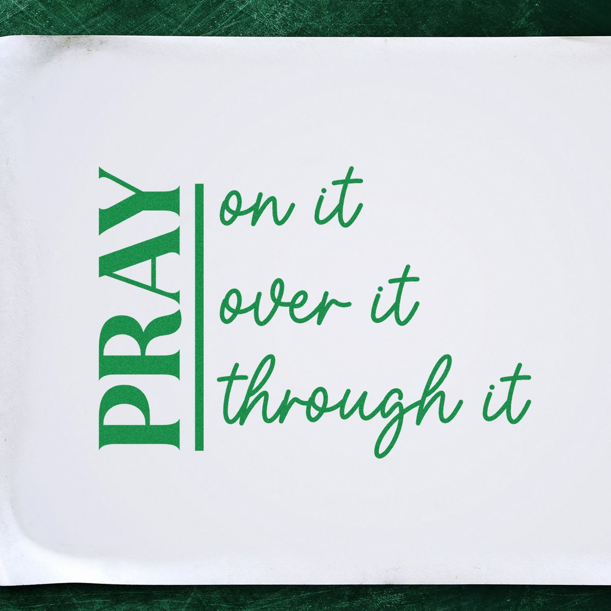 Green PRAY stamp/seal with cursive on it, over it, through it on a white background.