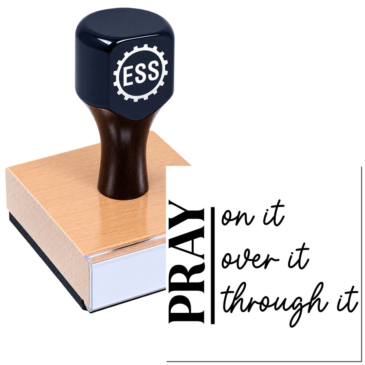 Black ESS rubber stamp seal on a wooden base with "Pray on it, over it, through it" text.