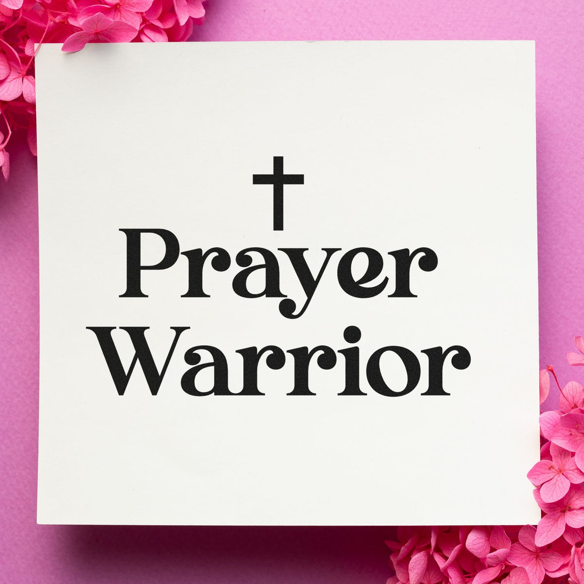White stamp and seal with black cross and Prayer Warrior text, framed by bright pink flowers.