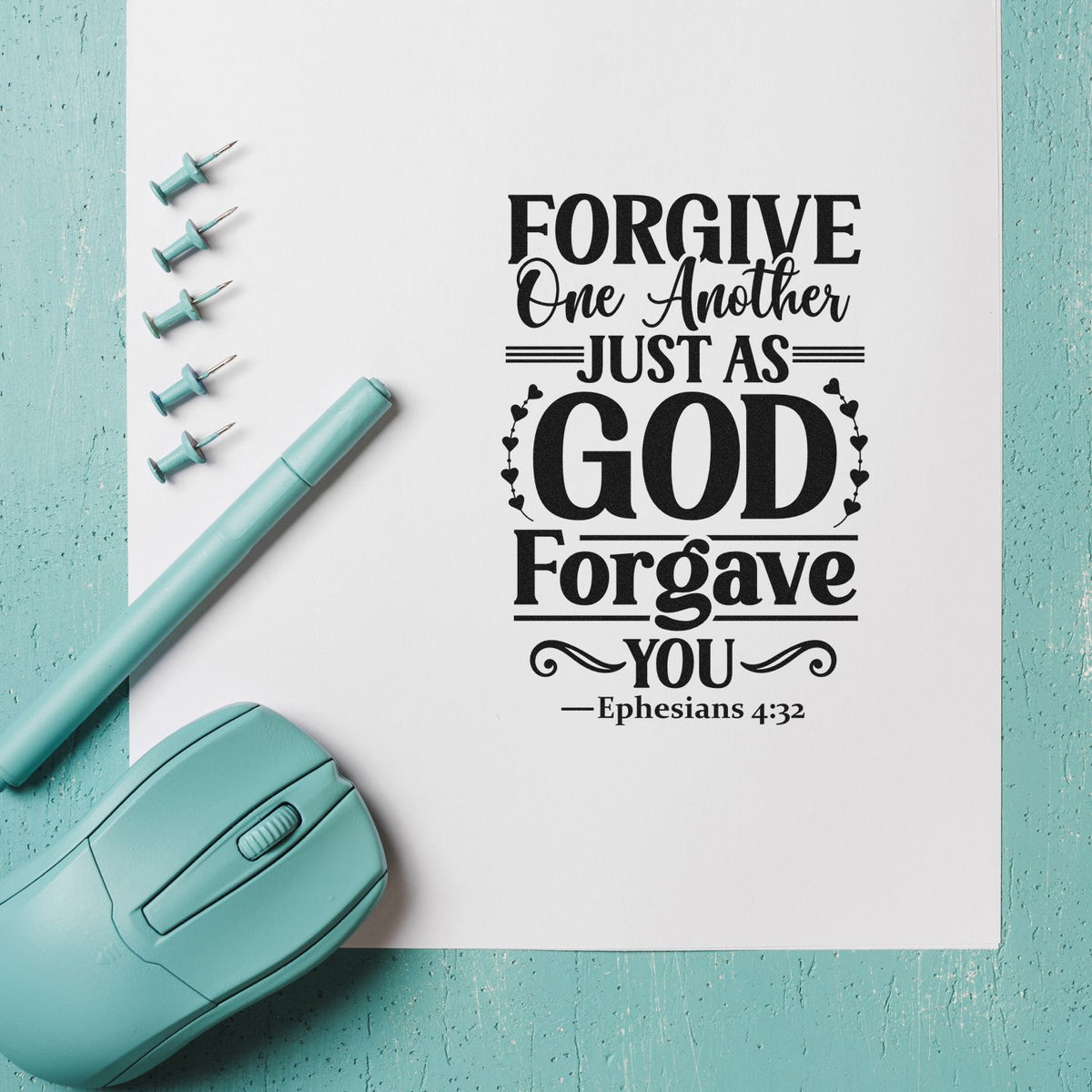 Teal stamp and seal tools beside a black Christian quote on white paper: Forgive One Another Just As God Forgave You.
