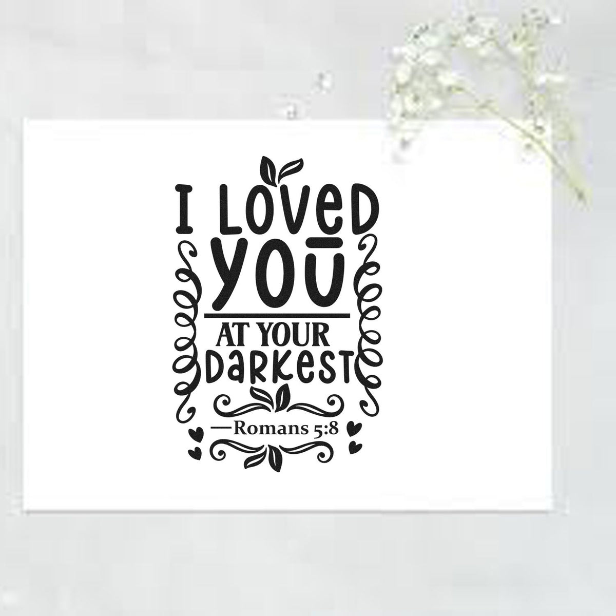 Black stamp and seal design reading I Loved You at Your Darkest with Romans 5:8, hearts, and floral flourishes on white.