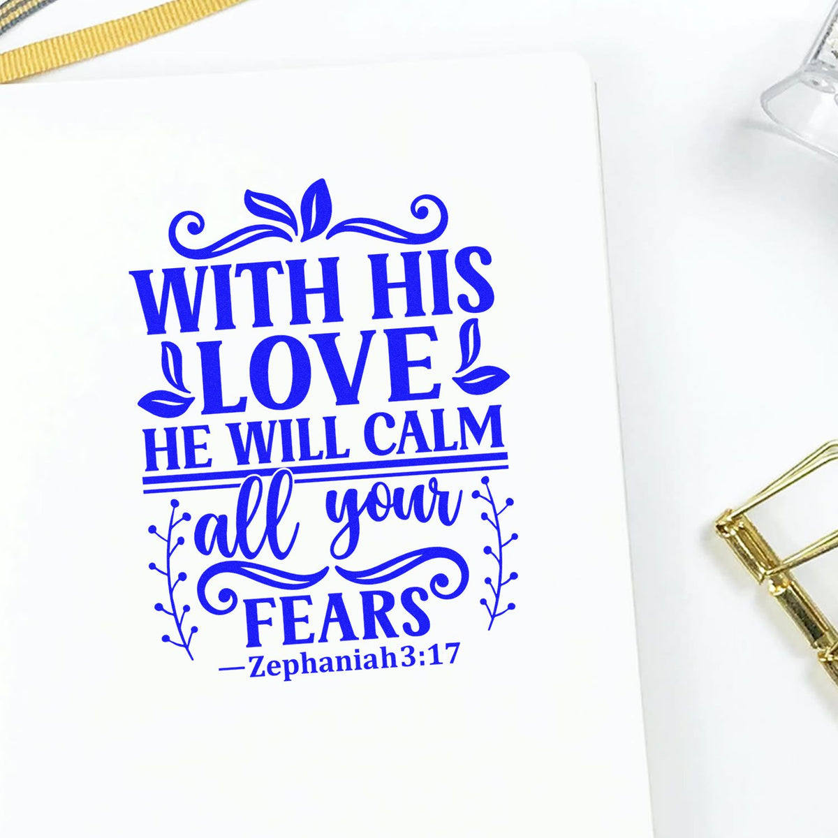 Blue decorative scripture stamp seal on white card, reading With His Love He Will Calm All Your Fears with floral accents.