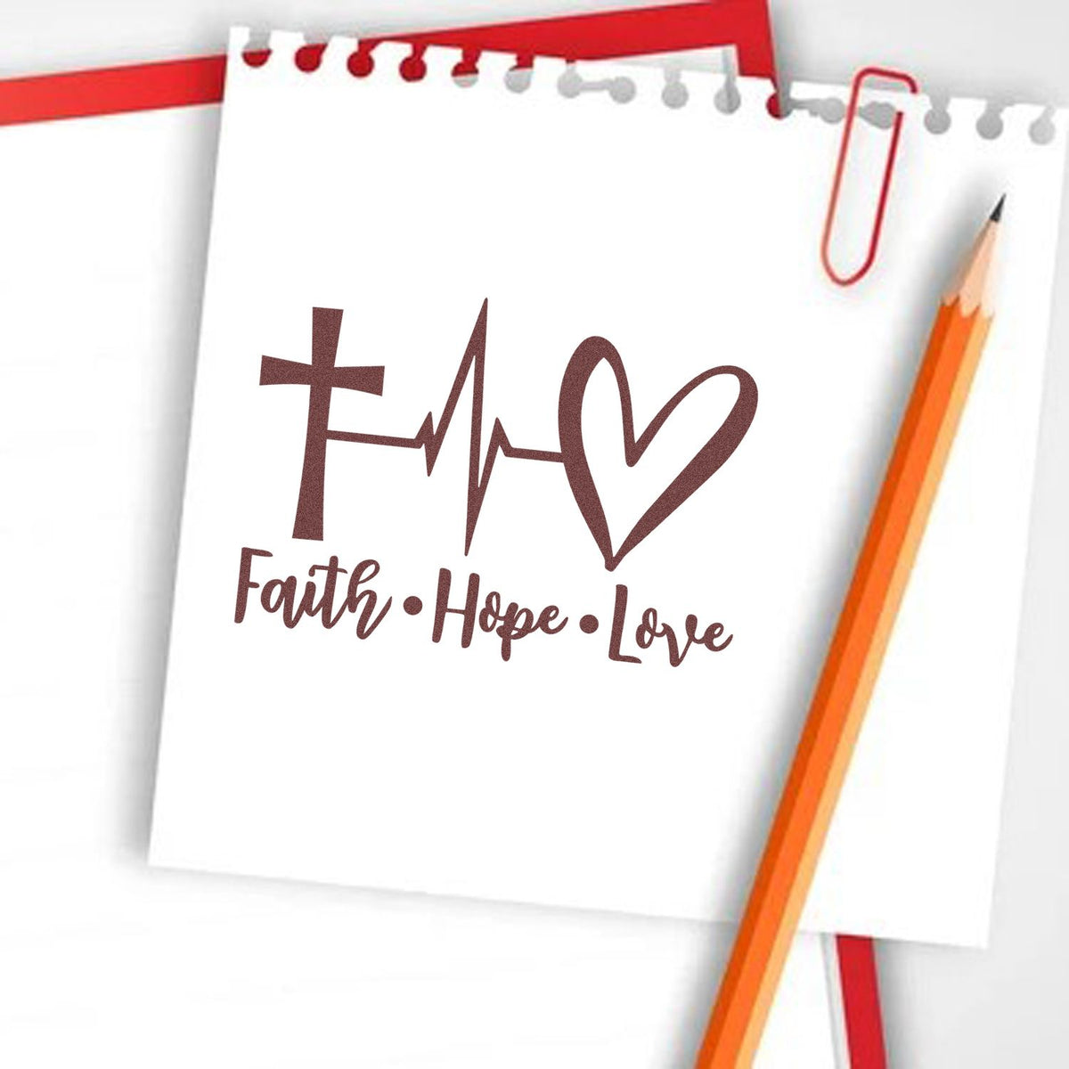 Maroon Faith Hope Love Christian stamp and seal design with cross-heart motif on white notebook paper, pencil and red paperclip