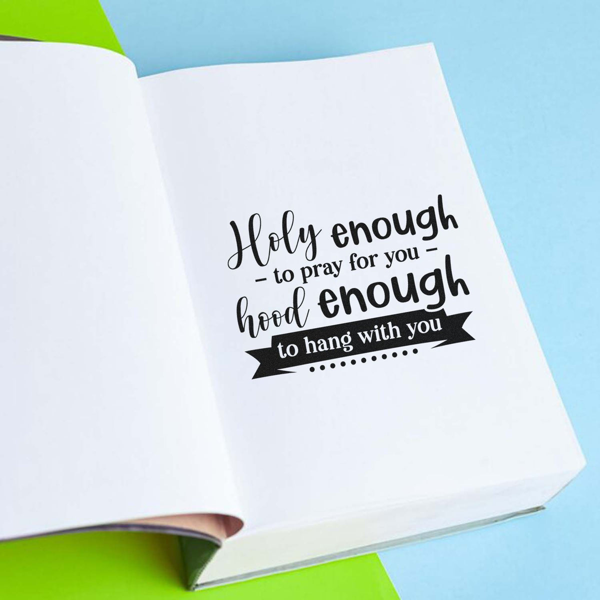 Black faith-themed stamp and seal on white paper, with Holy enough script on a blue and green background.