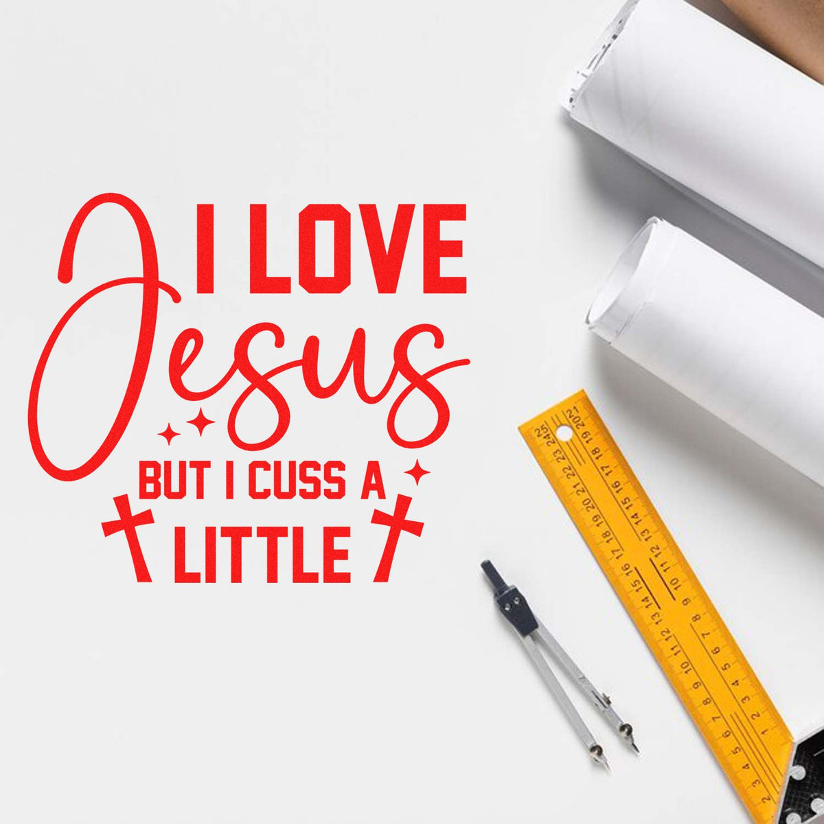 Red stamp design reading I love Jesus but I cuss a little, with crosses, on white background, beside yellow ruler and compass.