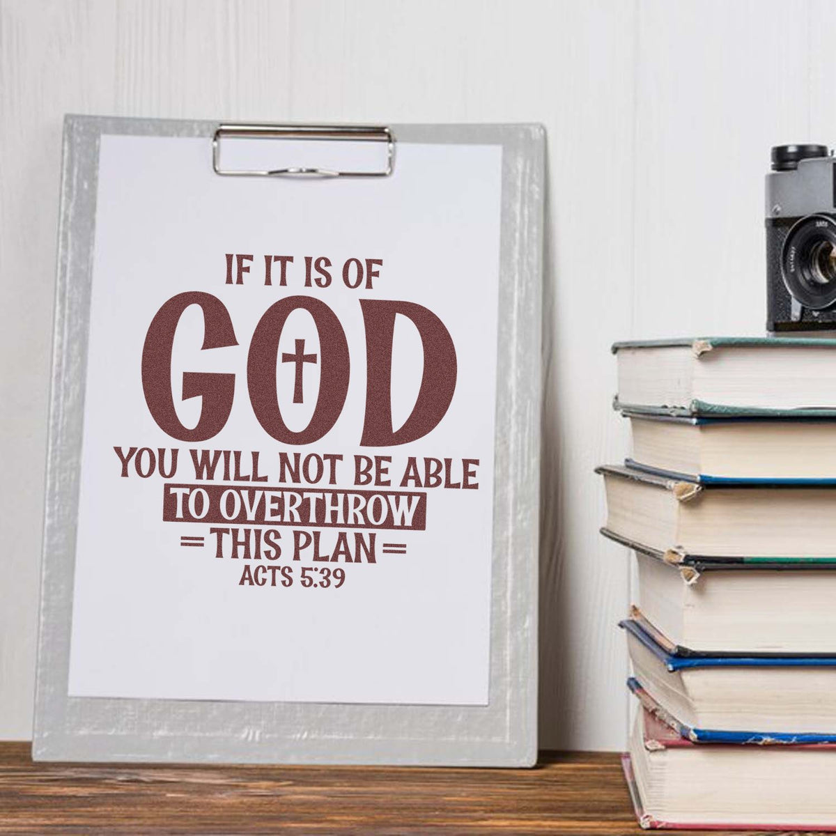 Burgundy custom stamp and seal design on a white clipboard, featuring a Bible verse beside stacked books.
