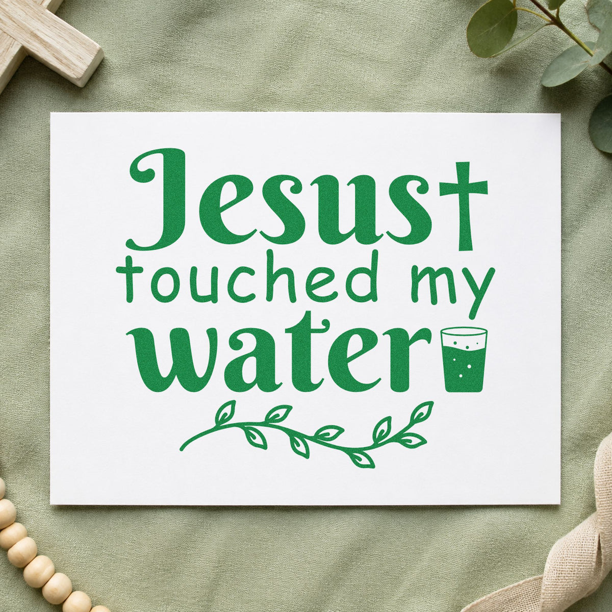 Jesus Touched My Water craft stamp imprint in green ink on a handmade project, one idea being wedding favor tags.