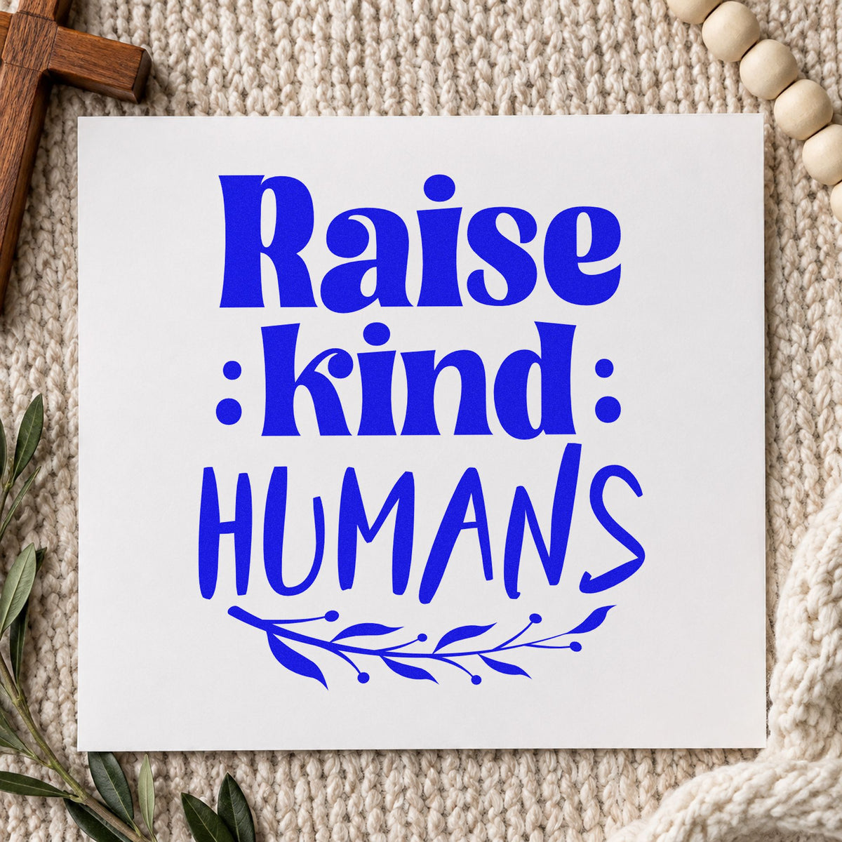 Raise Kind Humans craft stamp imprinted in blue ink on paper, a design suited to classroom signs.
