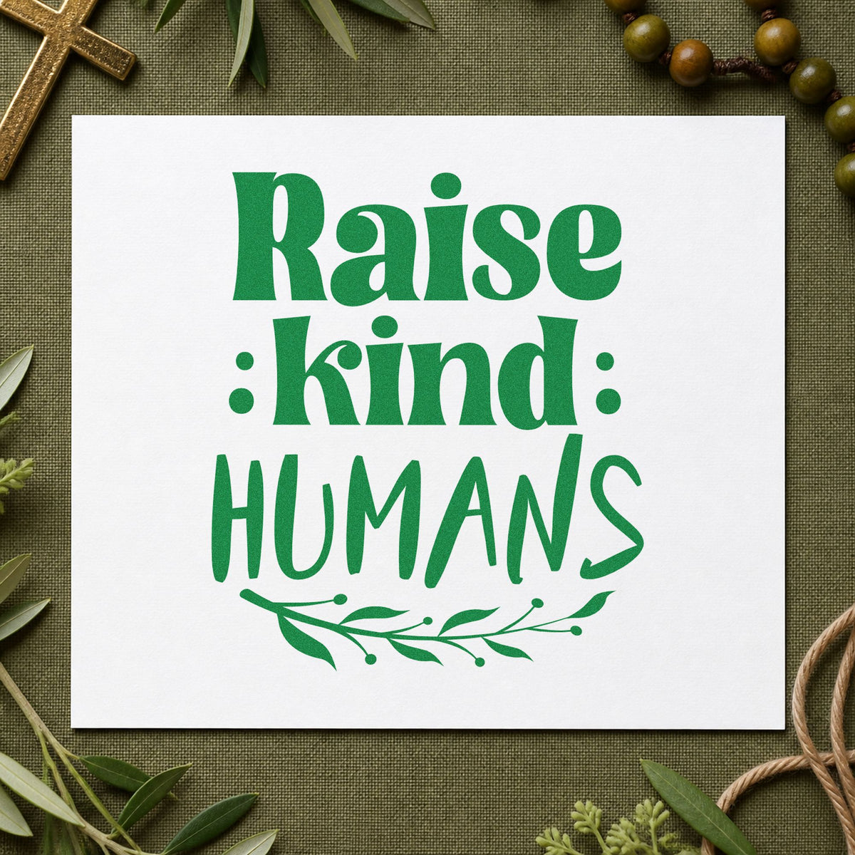 Raise Kind Humans craft stamp imprint in green ink on a handmade project, one idea being framed nursery art.