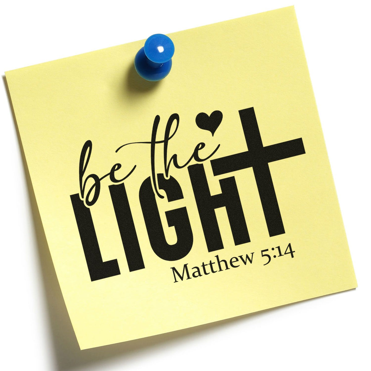 Yellow note pinned with blue pushpin featuring a black be the LIGHT Matthew 5:14 stamp and seal design.