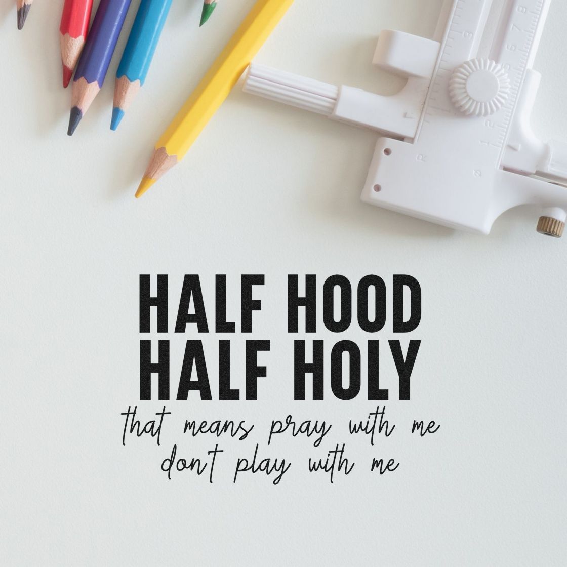White stamp and seal tool with colorful pencils beside bold black HALF HOOD HALF HOLY text on white paper.