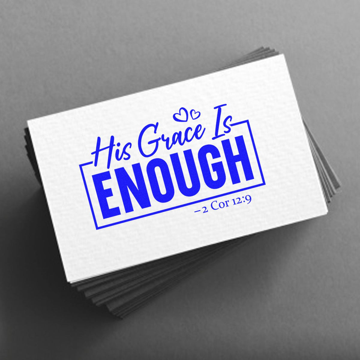 Blue custom stamp and seal on white cards reading His Grace Is ENOUGH with hearts and 2 Cor 12:9 on gray background.