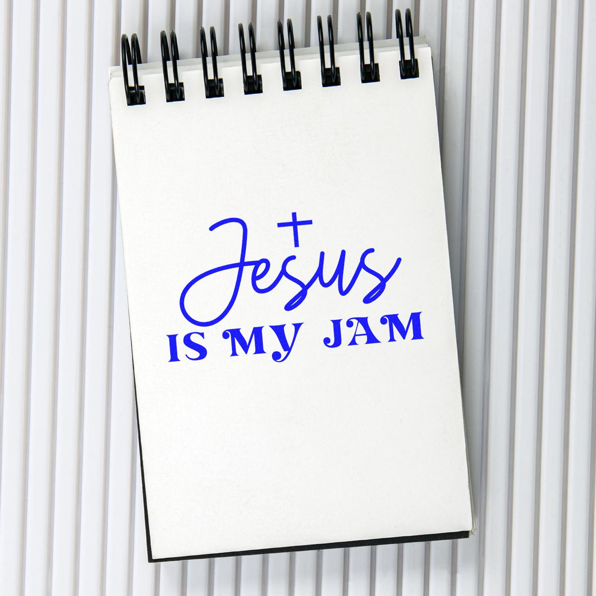 Blue Jesus is my jam stamp design on a white spiral notepad with black binding