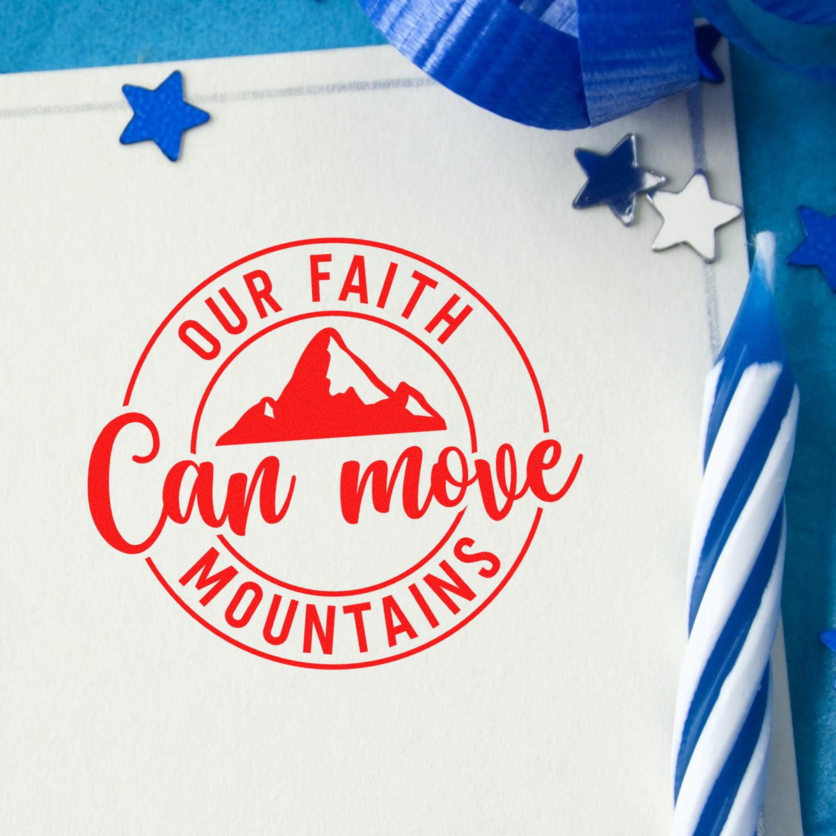 Red circular stamp seal reading Our Faith Can Move Mountains on white card, with blue ribbon and star confetti.