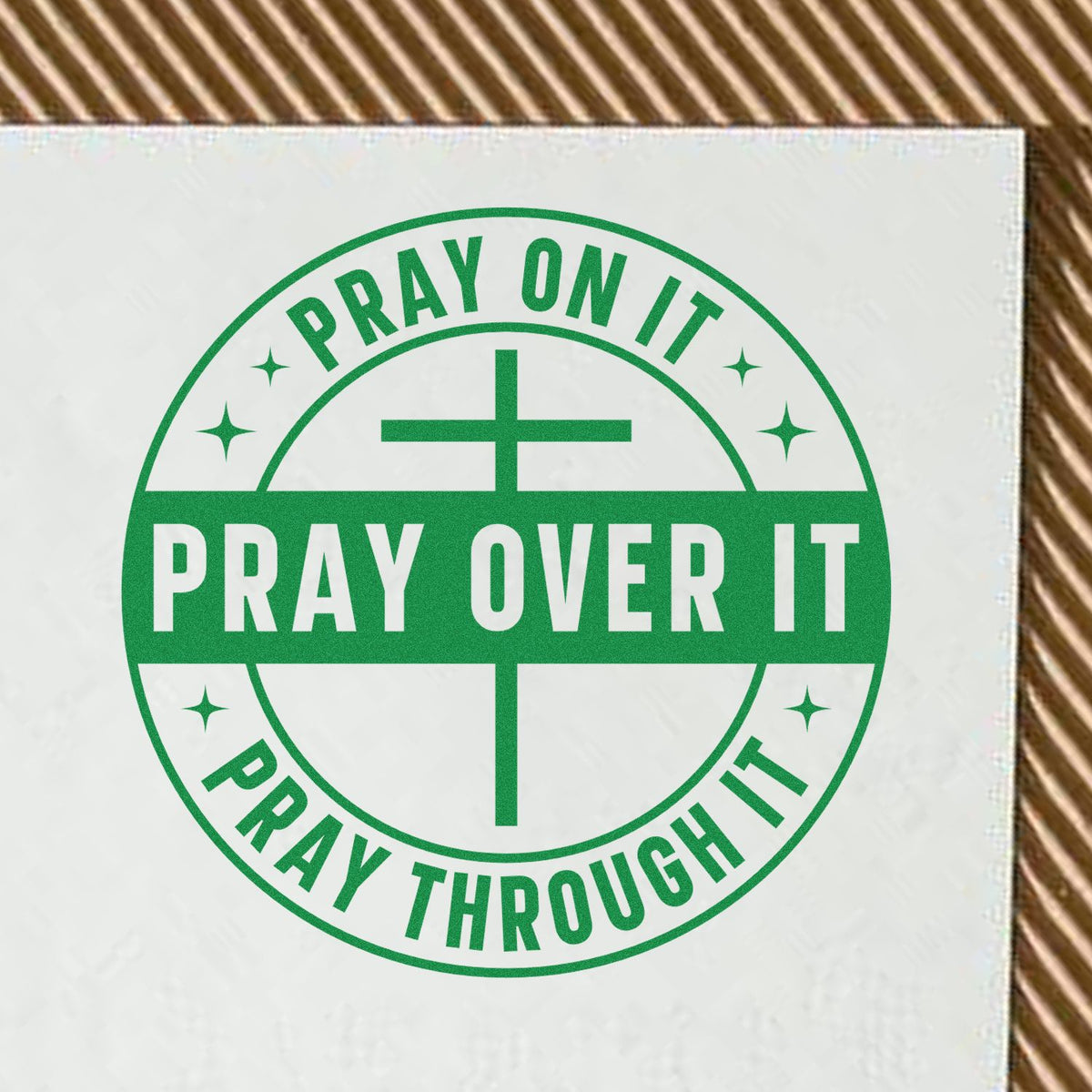 Green circular stamp seal with cross and white Christian text: Pray on it, pray over it, pray through it.