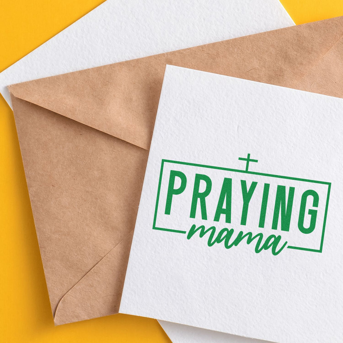 Green Praying mama stamp and seal on white card, beside a kraft envelope on a bright yellow background.