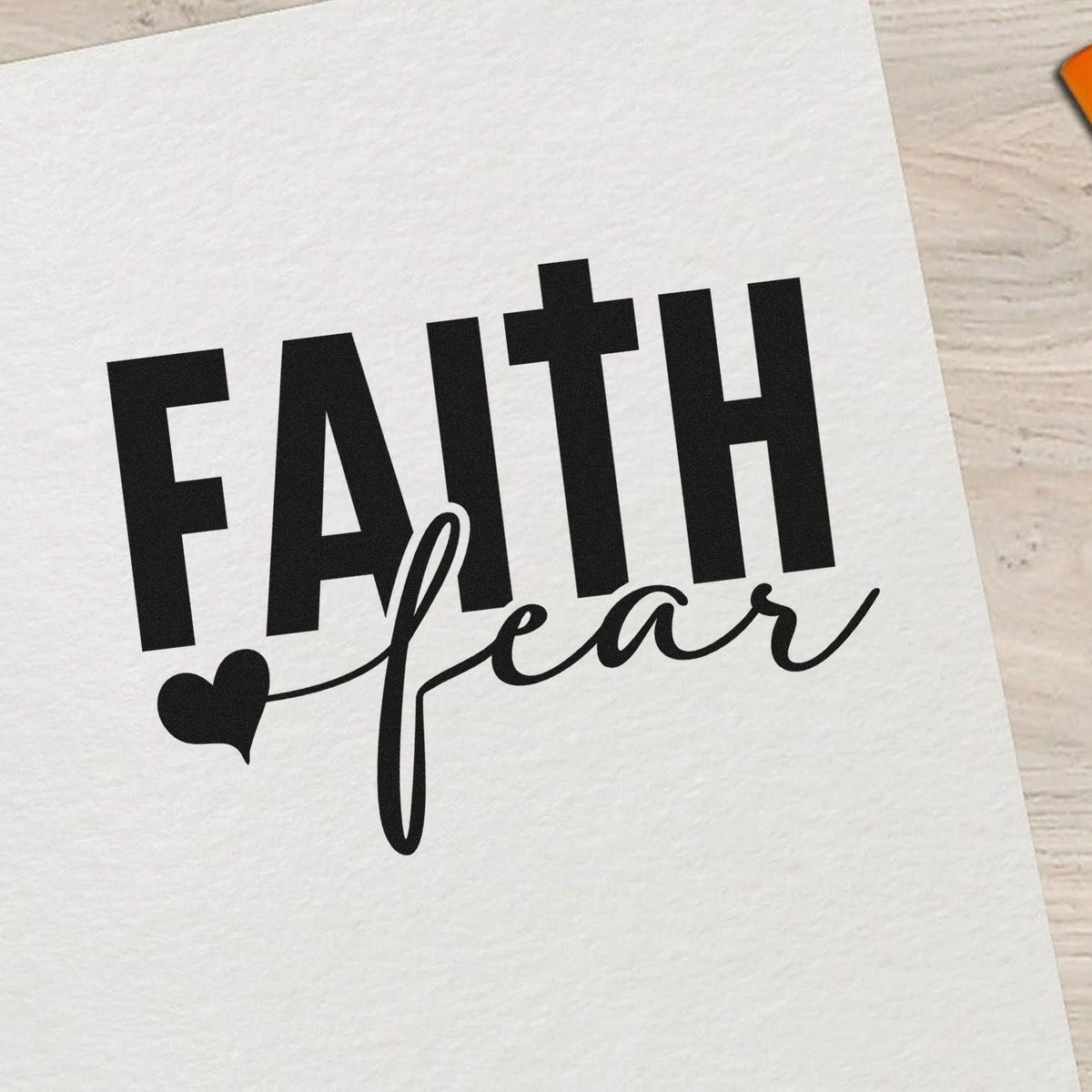 Black Faith over Fear stamp and seal design with heart on white paper
