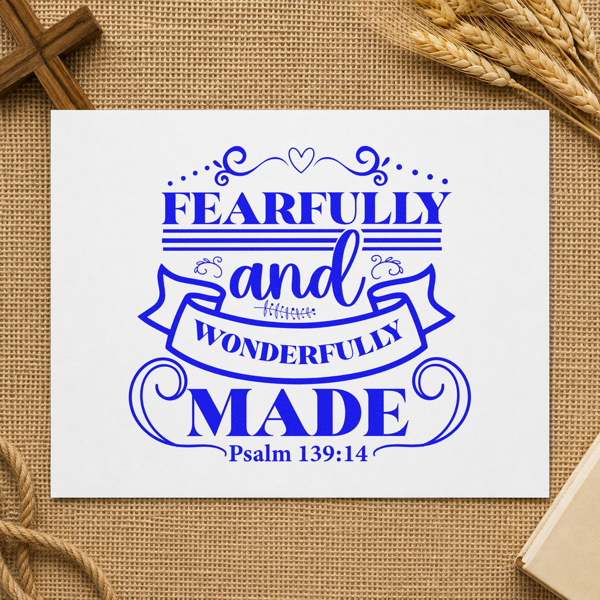 Fearfully Wonderfully Made Ribbon craft stamp imprinted in blue ink on paper, a design suited to down syndrome awareness.