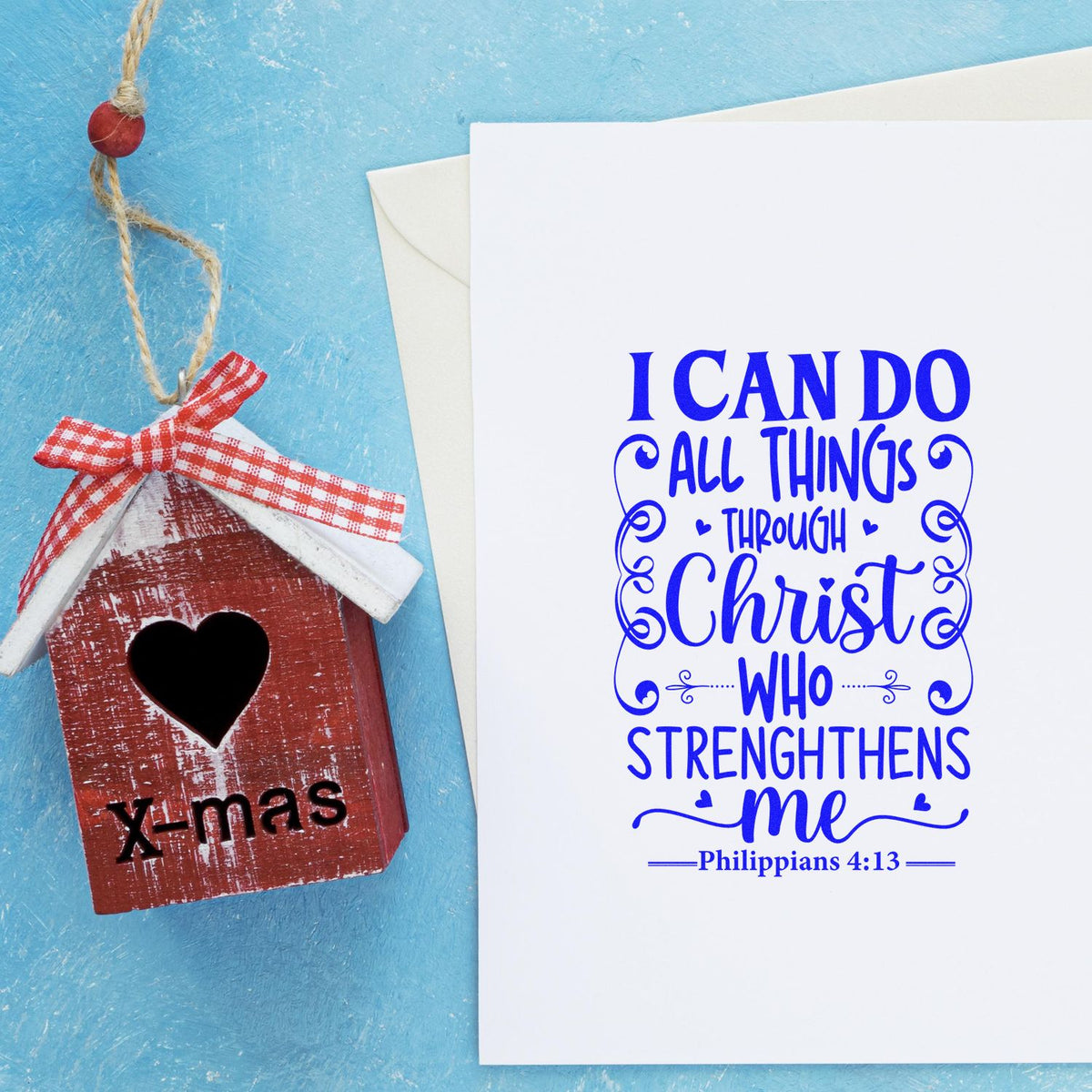 Rustic red x-mas birdhouse seal stamp with white roof and ribbon beside a white card with blue Philippians 4:13 lettering.