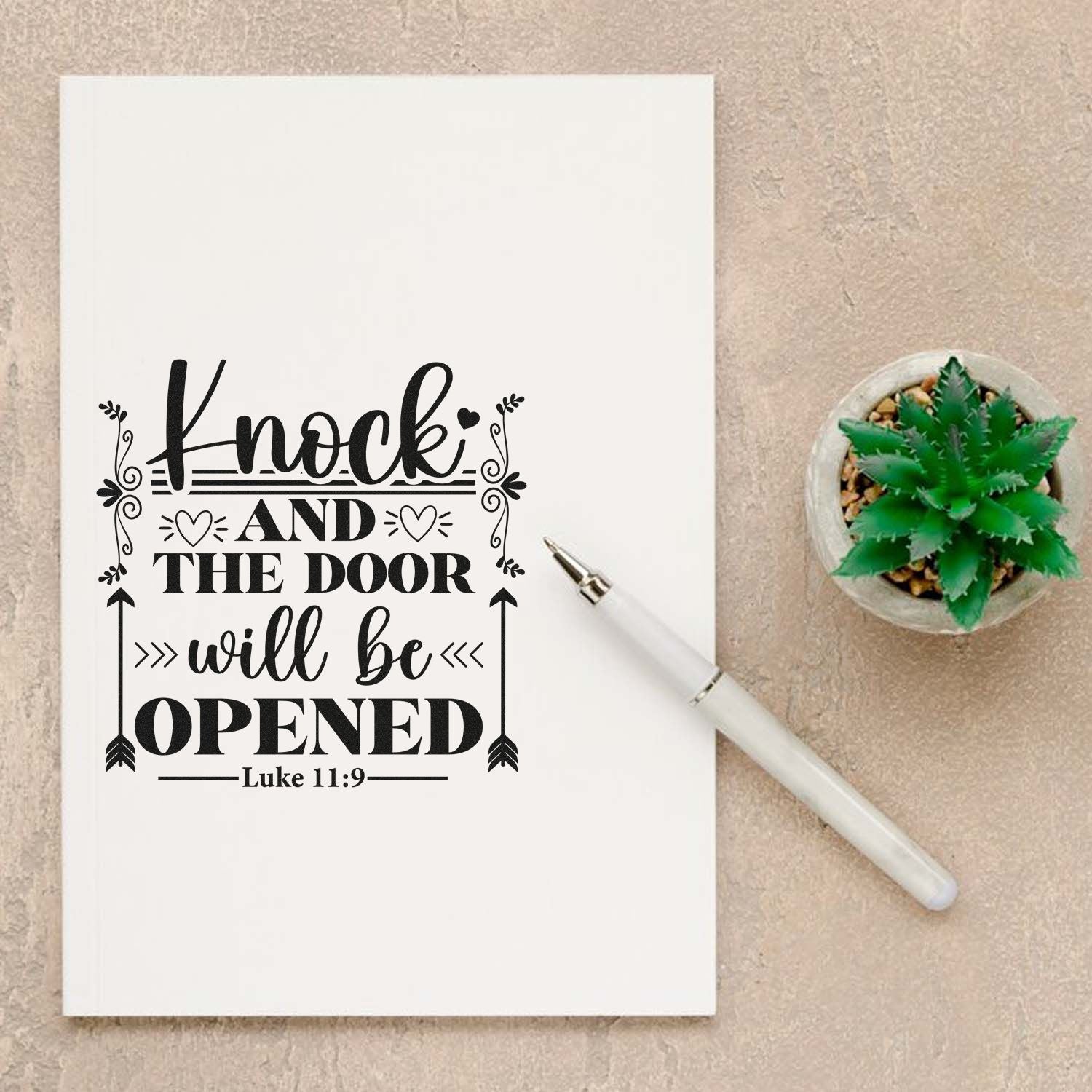 Black scripture stamp and seal on white card: Knock and the door will be opened Luke 11:9, with white pen and green succulent.