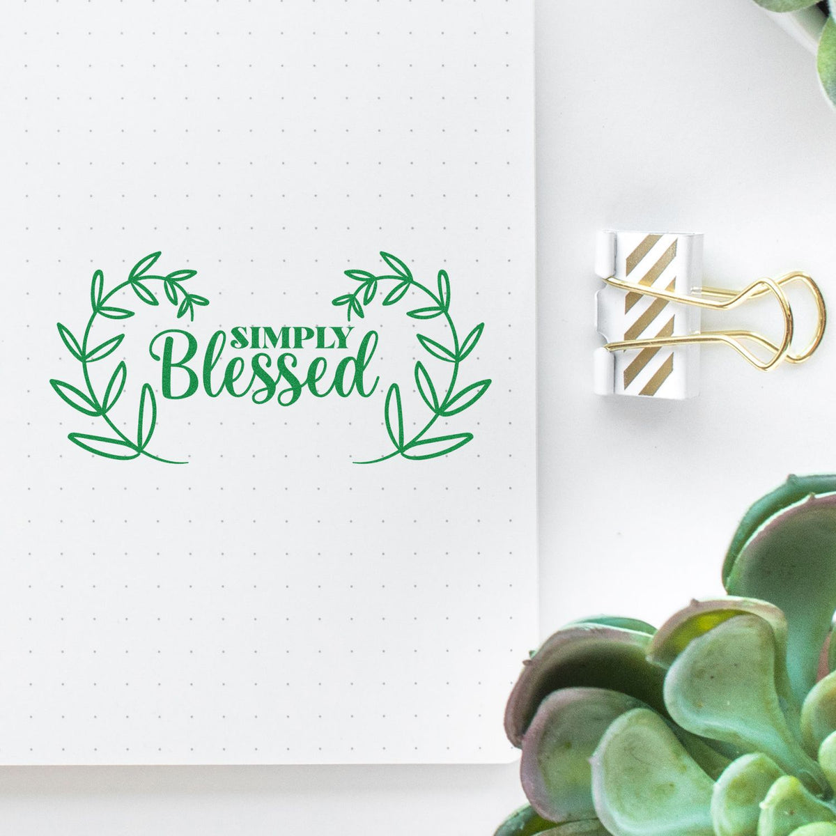 Green Simply Blessed leafy stamp and seal on dotted white paper, clipped with a gold binder clip.
