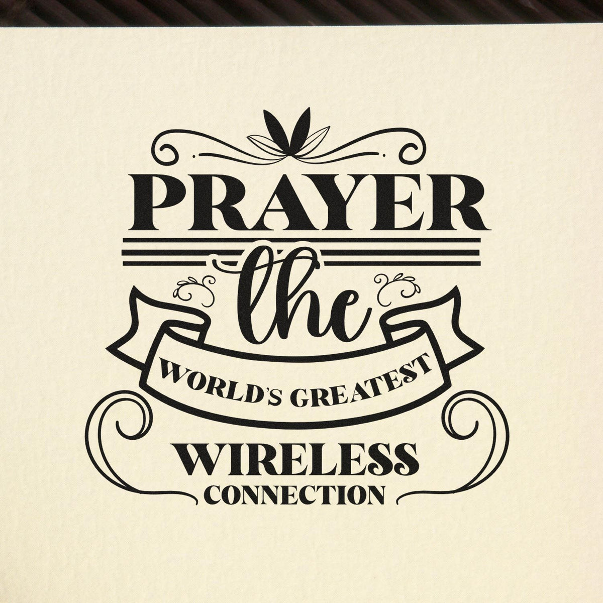 Black decorative stamp seal for Prayer: The Worlds Greatest Wireless Connection on a cream background.