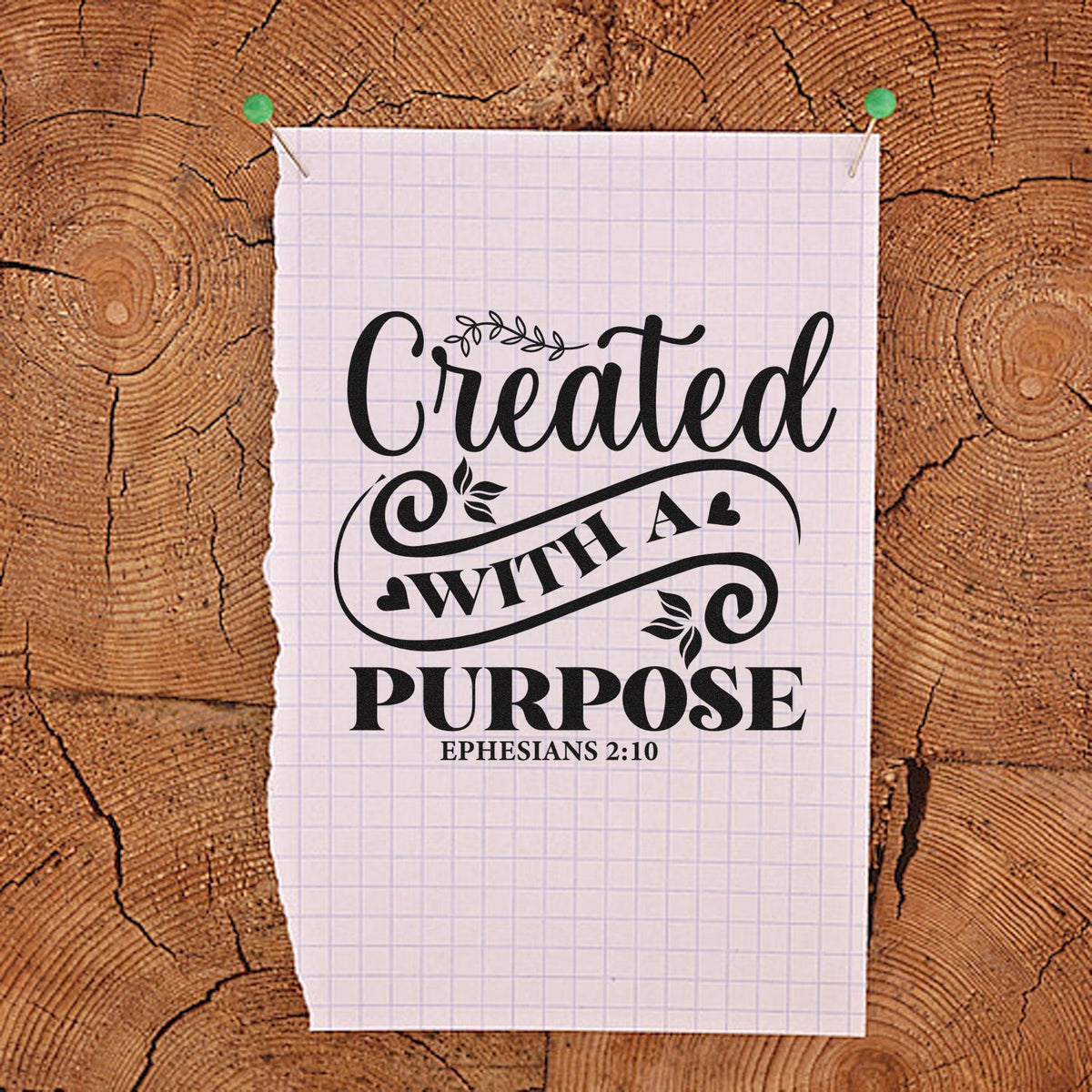 Custom stamp and seal design in black on grid paper, reading Created with a Purpose and Ephesians 2:10, pinned to wood.
