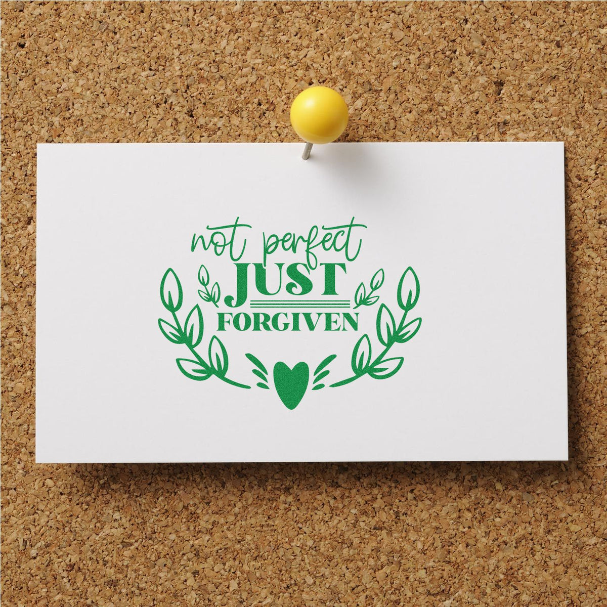 White stamp design on corkboard with yellow pushpin, green Not perfect, just forgiven text, leaf wreath and heart.