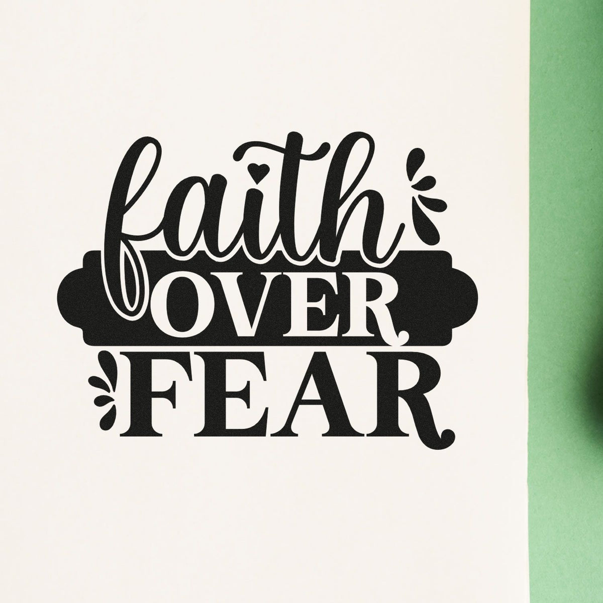 Black Faith Over Fear stamp seal design with script and bold lettering on white, accented by small decorative flourishes