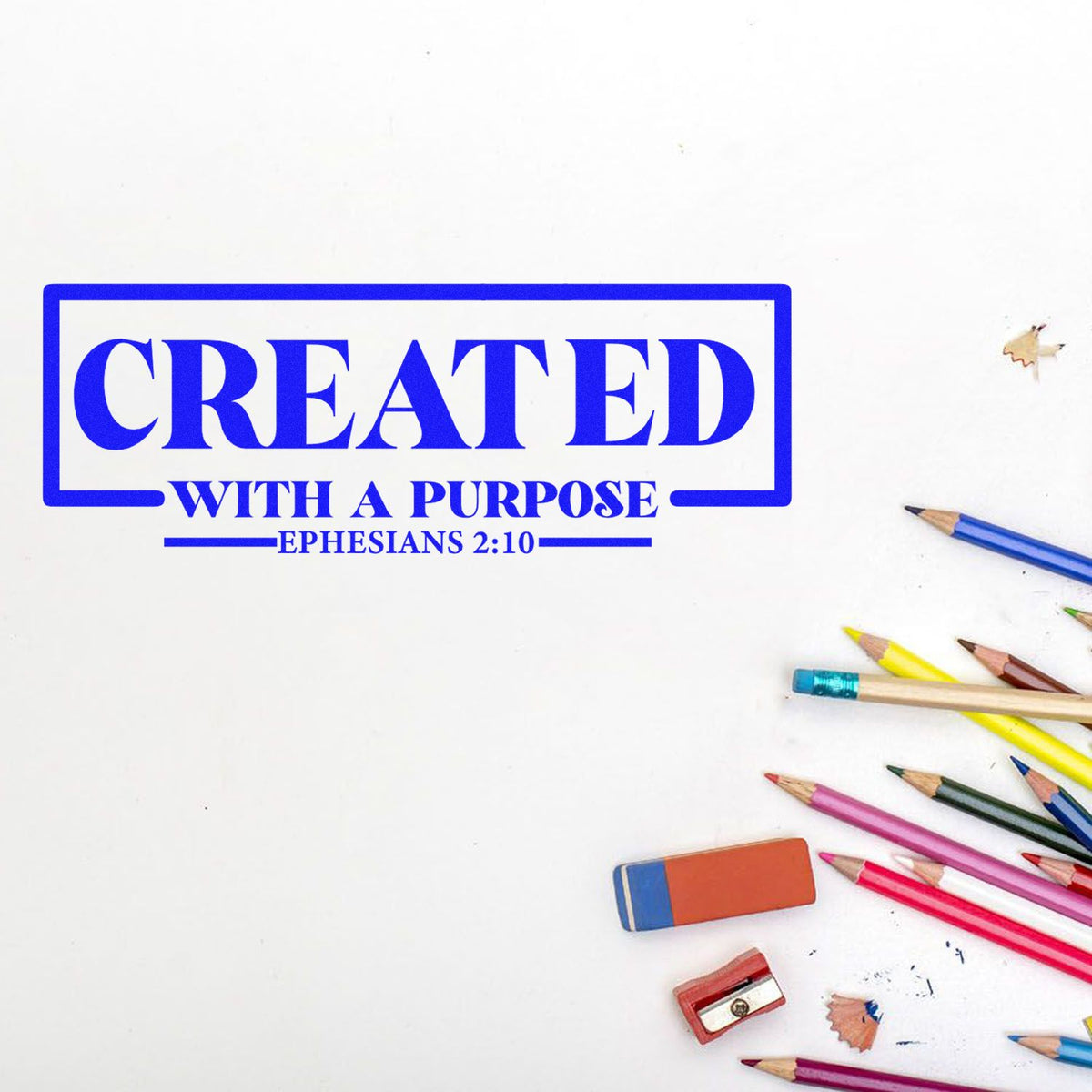 Blue stamp seal reading Created with a Purpose and Ephesians 2:10, beside colorful pencils, eraser, and sharpener on white.