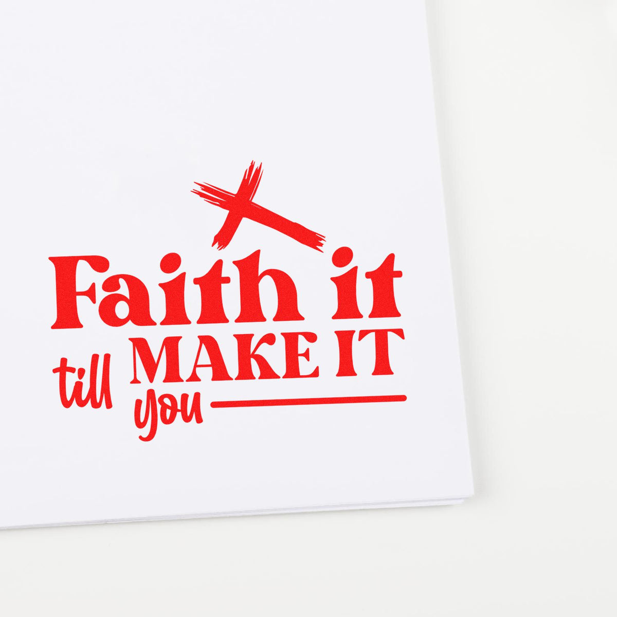 Red faith-themed stamp and seal on white paper with cross, reading Faith it till you MAKE IT.