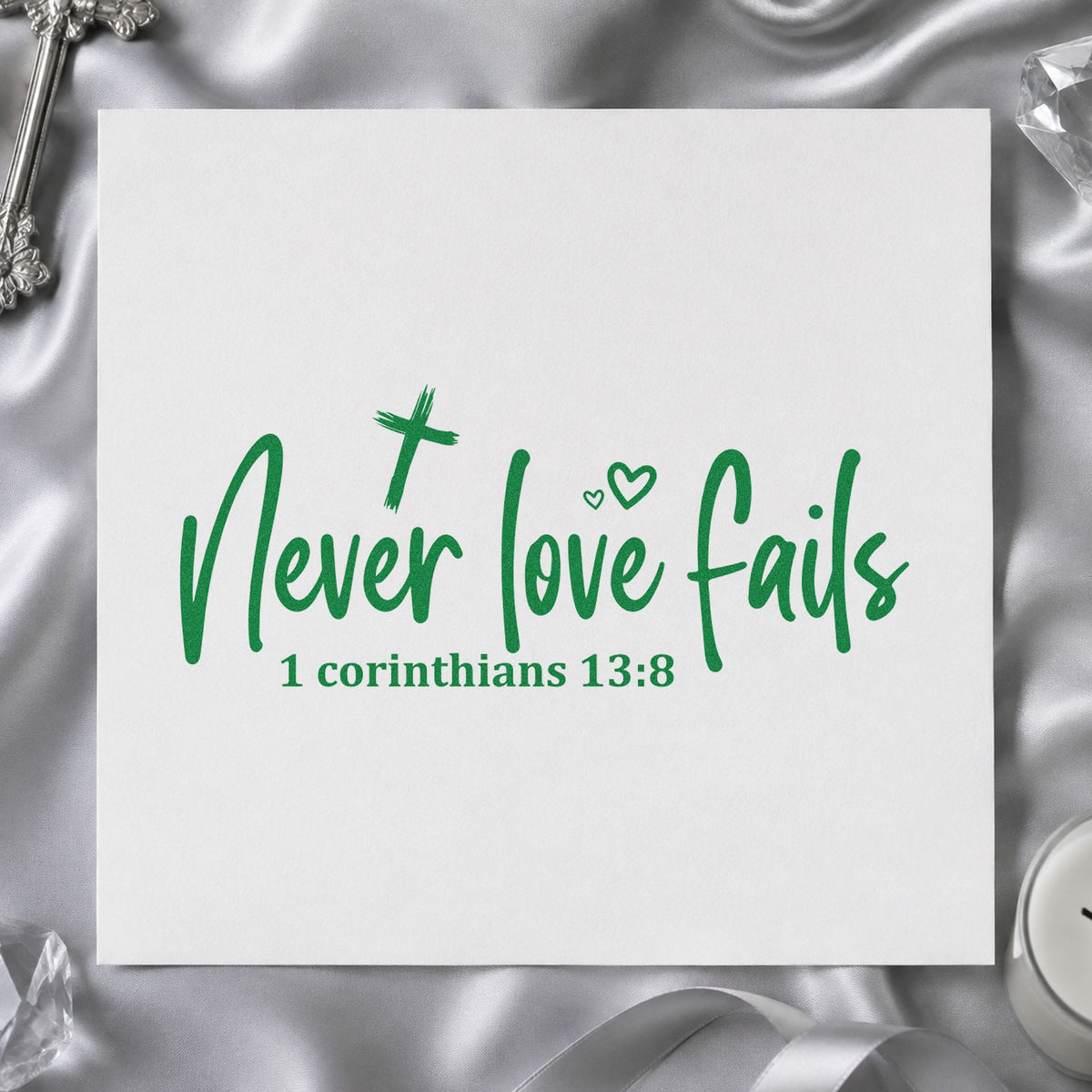 Never Love Fails craft stamp imprint in green ink on a handmade project, one idea being vow renewal favors.