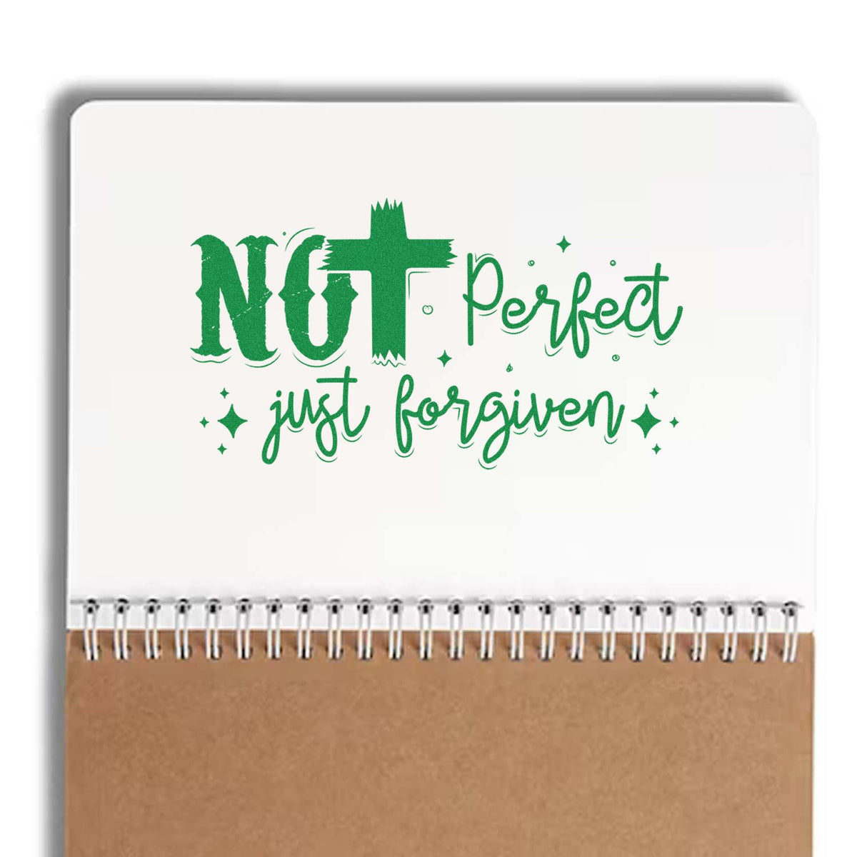 Green Not perfect, just forgiven stamp/seal design on a white spiral notebook with tan kraft bottom.