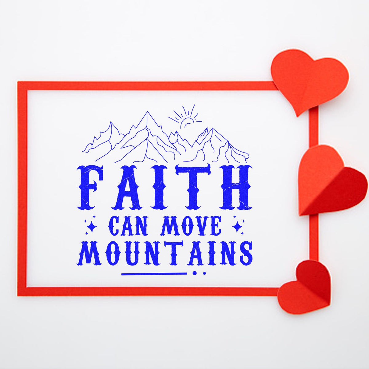 Blue faith-can-move-mountains rubber stamp with mountain line art, red border, and red heart seal accents on white.