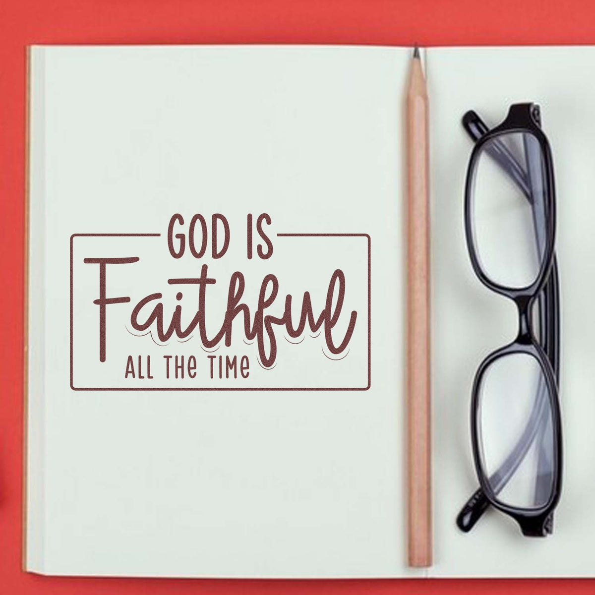 Faith-themed rubber stamp and seal on white notebook page, brown text, with pencil and black eyeglasses.